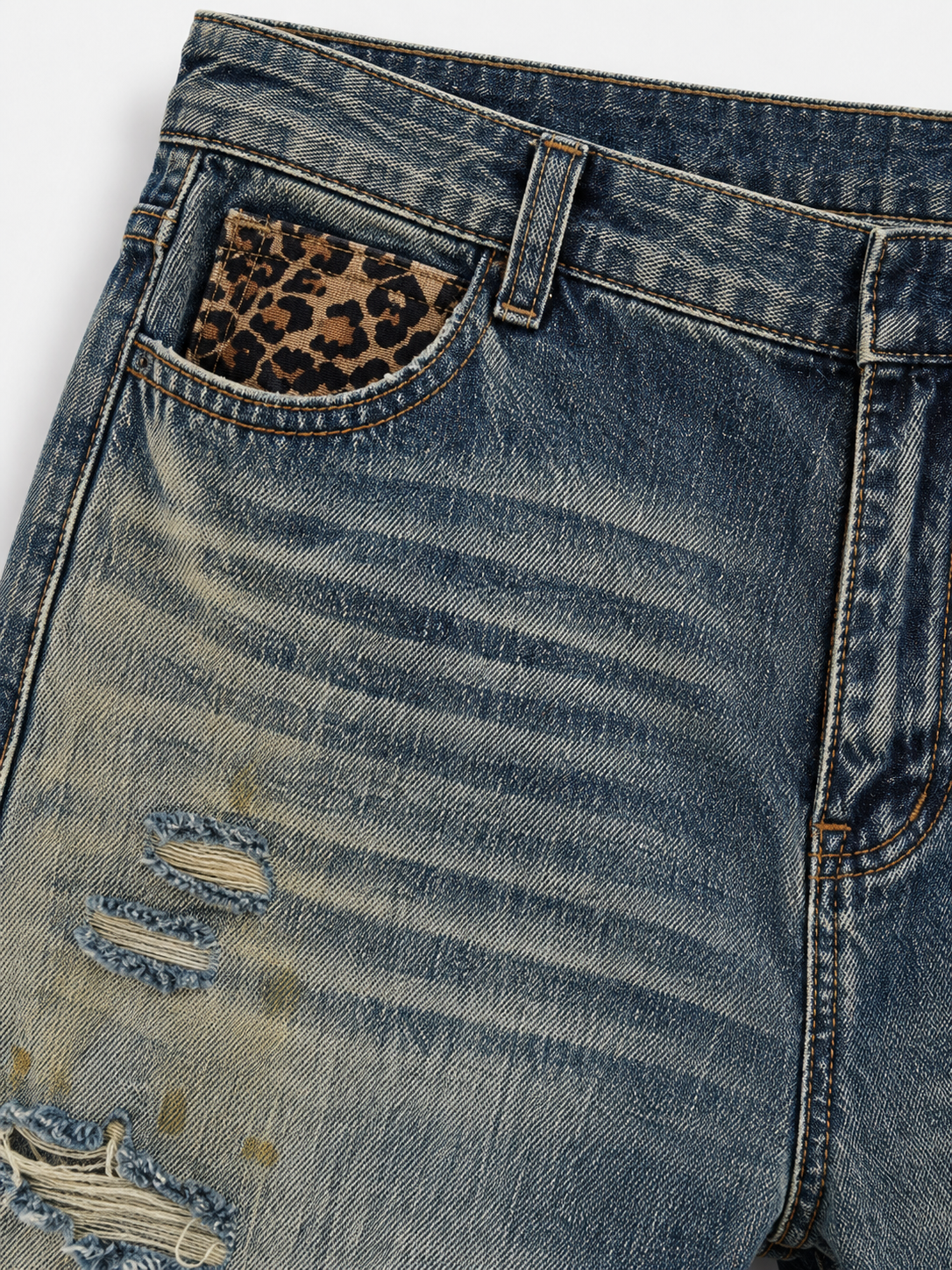 Distressed Baggy Jeans in Smoked Indigo. Close-up of the cheetah-print front pocket and faded wash.
