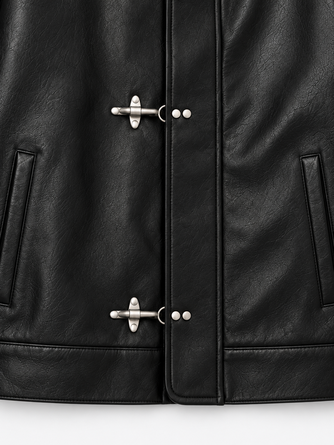 Obscura Leather Toggle Jacket in Jet Black. Close-up of the silver fireman-clasp fastening and side pockets.