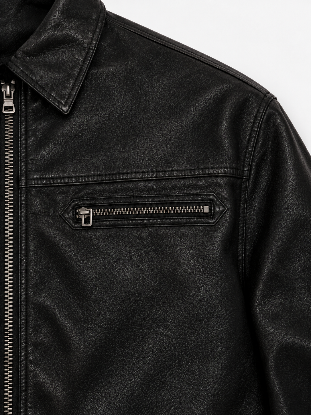 Strada Leather Jacket in Jet Black. Close-up of the collar, shoulder seam, and zipped chest pocket.