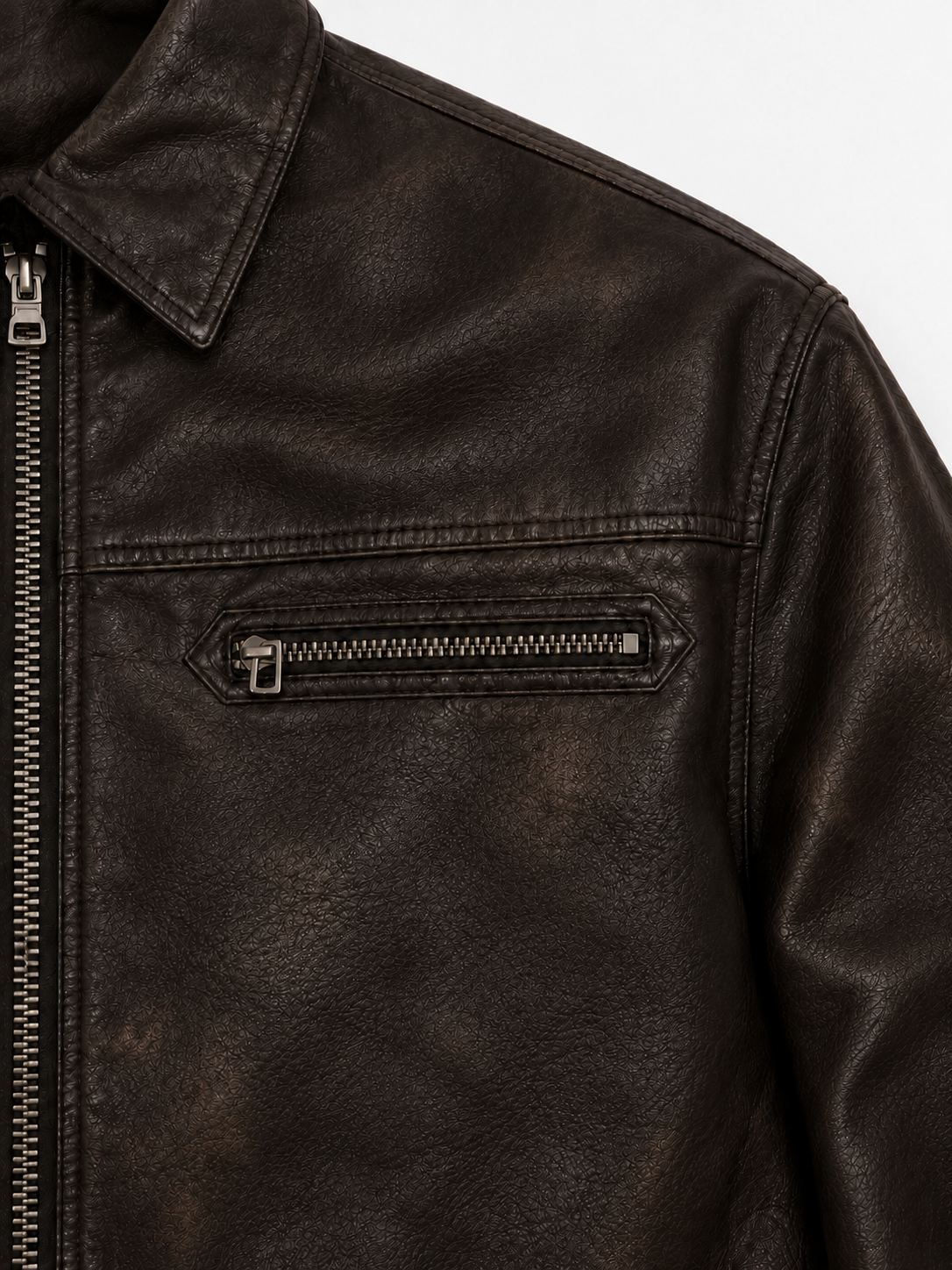 Strada Leather Jacket in Noir Brown. Close-up of the collar, shoulder seam, and zipped chest pocket.